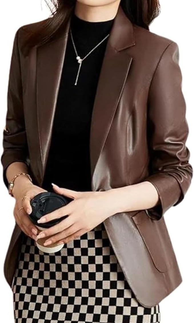 Woman confidently wearing a black lambskin leather blazer over a smart casual outfit.